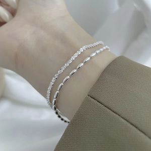 925 sterling silver double-layered bracelet set featuring dainty rice beads on a model wrist