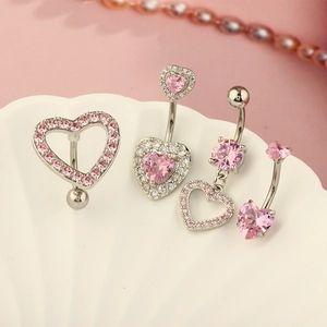 Pink heart belly button ring set with rhinestones on a decorative shell background