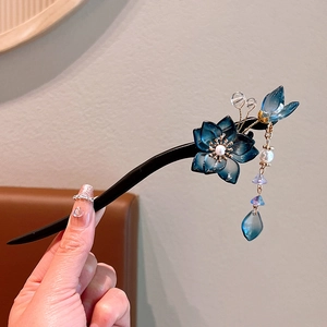 Detail showing ebony wood hair pin with blue glass flowers, pearls and crystal tassels