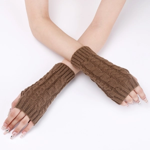 Close-up of brown fingerless knitted wrist warmers with classic cable knit texture