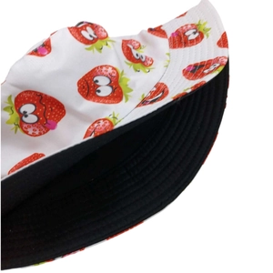 Detail showing the reversible inner black lining and cartoon strawberry print on a sun hat