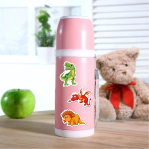 Pink kids' stainless steel thermos with colorful dinosaur cartoons on a wooden desk