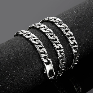 Detailed view of silver stainless steel chain with lobster clasp on a black textured stand