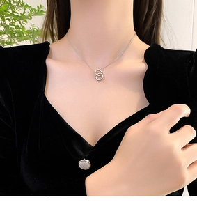 Elegant close-up of a silver double ring pendant necklace on a model's neck