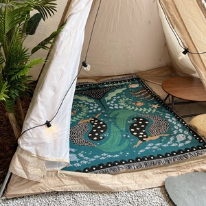 Detailed weave of bohemian picnic blanket featuring mermaid patterns and fringe edges