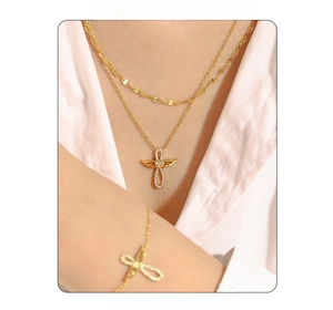 Détail de l'ensemble collier croix ailes d'ange dorées et bracelet assorti