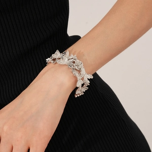 Détail d'un bracelet manchette argenté avec texture florale irrégulière en métal poli