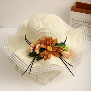 Fashionable sun straw hat with wide lace brim and large sunflowers for beach vacations