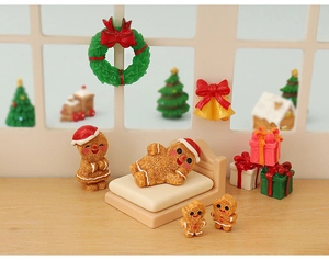 Close-up of miniature resin gingerbread man figurines with holiday wreaths and gift boxes