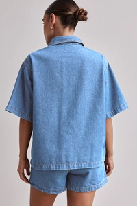 Rückansicht eines lässigen, lockeren blauen Denim-Hemds und passenden Shorts für Damen