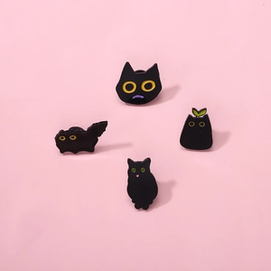 Set of four cute black cat enamel pins with large yellow eyes on pink background