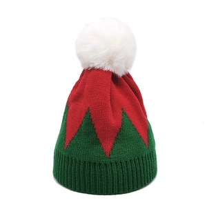 Detailed knit texture of a Christmas elf pom-pom beanie with red and green zigzag patterns