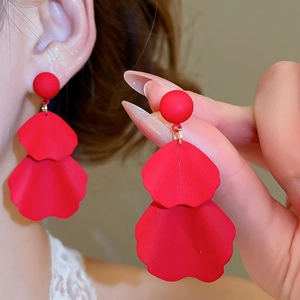 Close-up of red petal tassel earrings showing matte texture and gold link details
