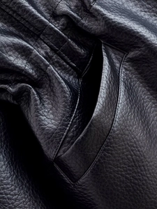 Detailed close-up showing the smooth black leather texture and stitching of side pocket
