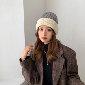 Detailed knit texture and plush fleece lining of a gray and beige beanie hat