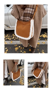 Brown suede shoulder bag with white faux fur trim and adjustable strap in autumn setting