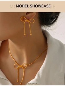 Close-up of gold butterfly jewelry set including a fine necklace and matching earrings