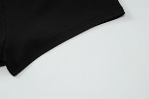 Gros plan détaillé montrant les doubles coutures de précision sur le tissu noir
