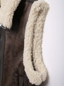 Detail of brown faux suede vest showing white teddy fleece lining and zipper closure