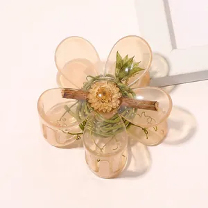 Detailed view of translucent amber flower hair claw clip with metallic spring mechanism