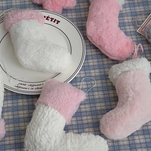 Gros plan de chaussettes de Noël en peluche rose avec texture douce en fausse fourrure
