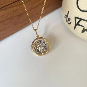 Macro view of gold coin pendant with silver relief portrait on a vintage chain necklace