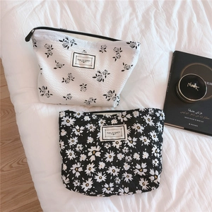 Detail of floral bubble fabric makeup bags with Time to Party label and zipper closure