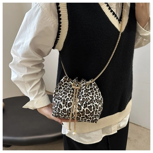Detail of leopard print bucket bag featuring gold chain and white pearl accents