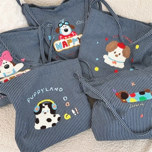 Detail of striped canvas tote bags featuring various cute puppy embroidery patterns