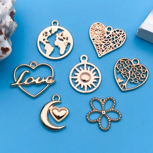 Set of seven golden metal charms featuring earth, heart, and love designs on blue background