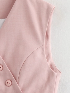 Close-up of pink vest fabric texture with matching buttons and double-breasted detail