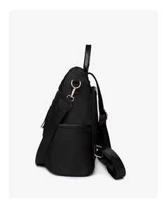 Side view of black nylon backpack showing quilted texture and golden metal hardware