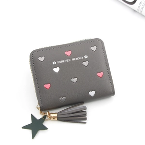Detail of grey PU leather wallet with heart embroidery, star charm and tassel zipper
