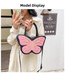 Detail of pink butterfly bag with golden glitter wings and black handle for women