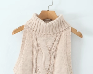 Detail of beige high-neck cable knit sleeveless sweater vest on a wooden hanger