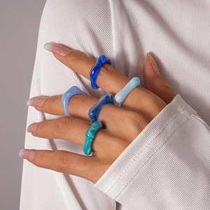 Gros plan de bagues en résine empilées avec textures marbrées bleues et design irrégulier
