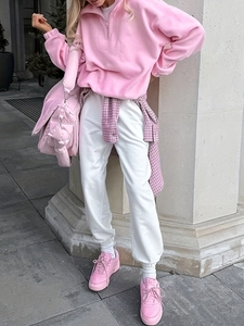 Detail of pink half-zip fleece sweatshirt with logo and matching quilted crossbody bag