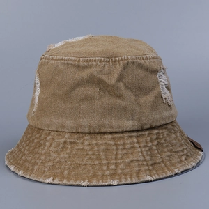 Détail d'un chapeau bob en denim marron vieilli avec bords effilochés et effet usé