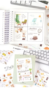 Detailed view of hand-painted stationery stickers on a white loose-leaf notebook