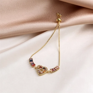 Close-up of heart charm bracelet with pave-set white zircons and colorful baguette stones