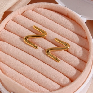 Minimalist gold plated stainless steel wave earrings displayed in a velvet jewelry box