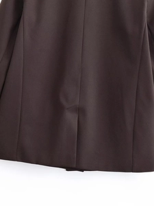 Detailed close-up showing the precise single back vent of a dark brown blazer jacket