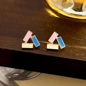 Detail of geometric pearl earrings with pink and blue enamel inlay on gold frame