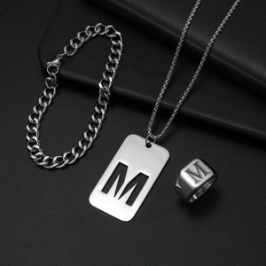 Details des silbernen Edelstahlschmuck-Sets mit dem Buchstaben M auf Anhänger und Ring