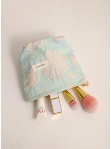 Light blue jacquard makeup bag with pink flower embroidery and golden zipper top view