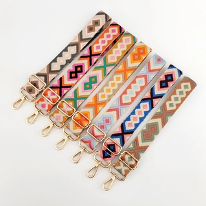 Detail of seven colorful geometric jacquard bag straps with gold metal swivel snap hooks