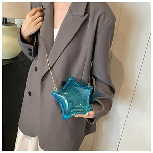 Detail of transparent blue star-shaped crossbody bag with elegant gold chain strap