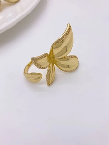 Close-up of golden four-petal flower ring with micro-set zircon and layered leaf petals