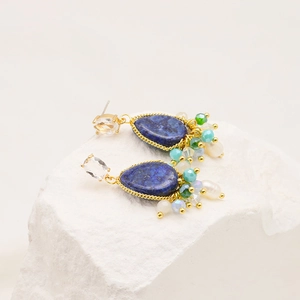 Detail of vintage bohemian drop earrings with blue lapis-like stones and white pearls