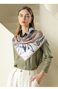Close-up of a floral print twill square scarf styled on a model with a green shirt